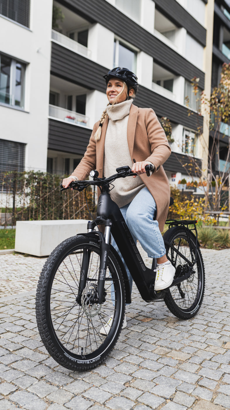 A Lady riding a Crussis - ONE-Country 7.10 City E-Bike – Panasonic Motor, 522Wh Battery, 130km Range, Low Step Frame in an urban setting